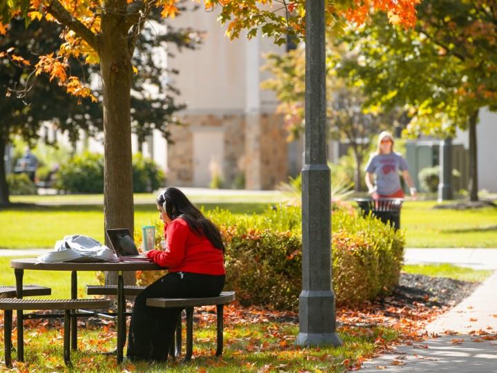 A student studies outside at a table